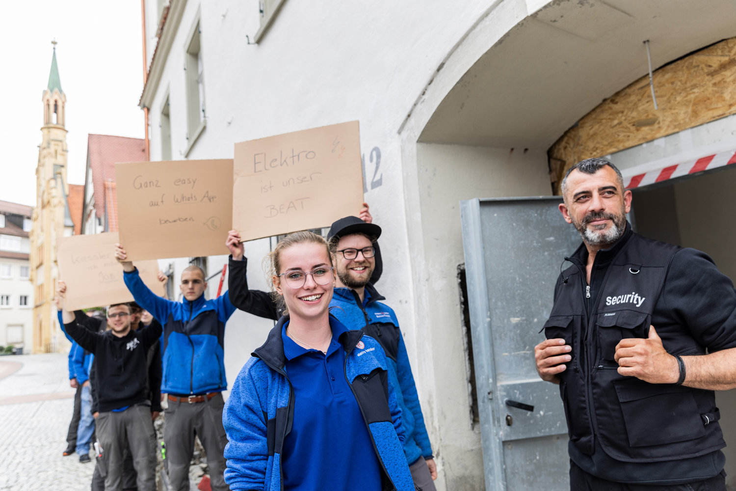Mehrere junge Menschen halten beschriebene Schilder hoch