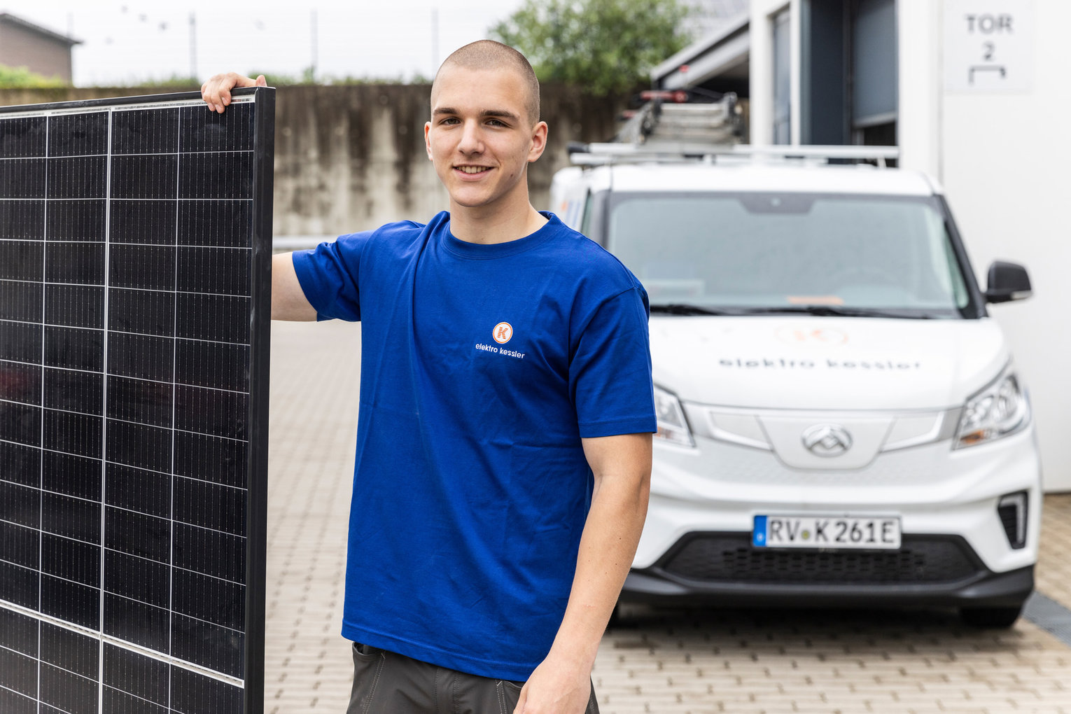 Ein Mitarbeiter von Elektro Kessler steht vor einem Firmenwagen