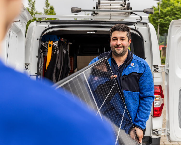 Zwei Mitarbeiter von Elektro Kessler laden ein Photovoltaik Element aus dem Auto aus